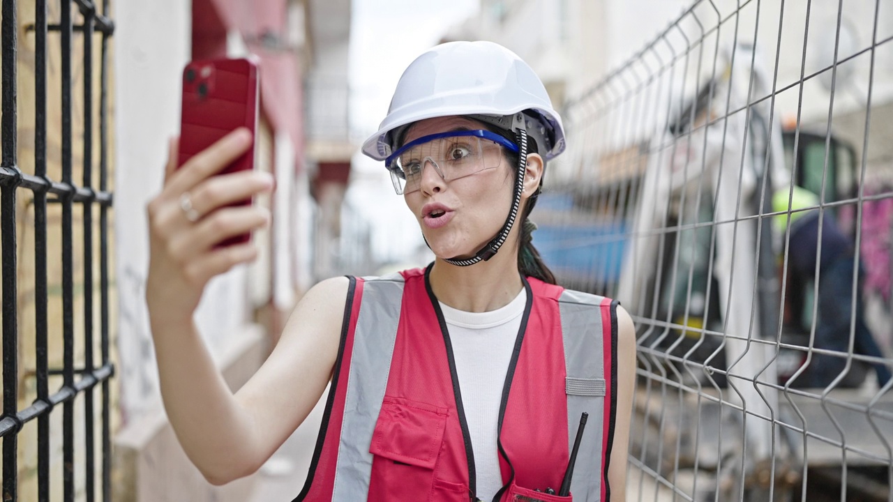 年轻美丽的西班牙女建筑工人在街上进行视频通话视频素材