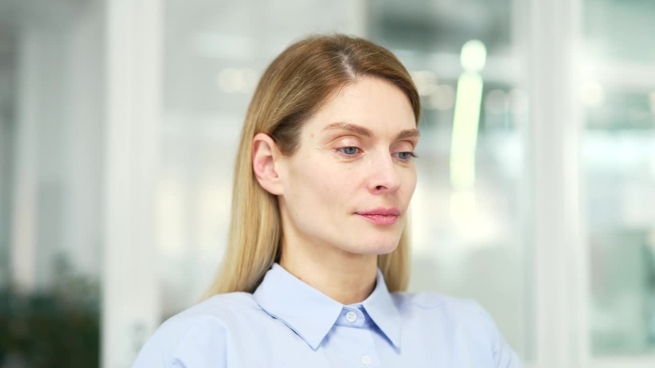 一个安静的女人闭着眼睛在现代办公室里放松的特写。肖像视频素材