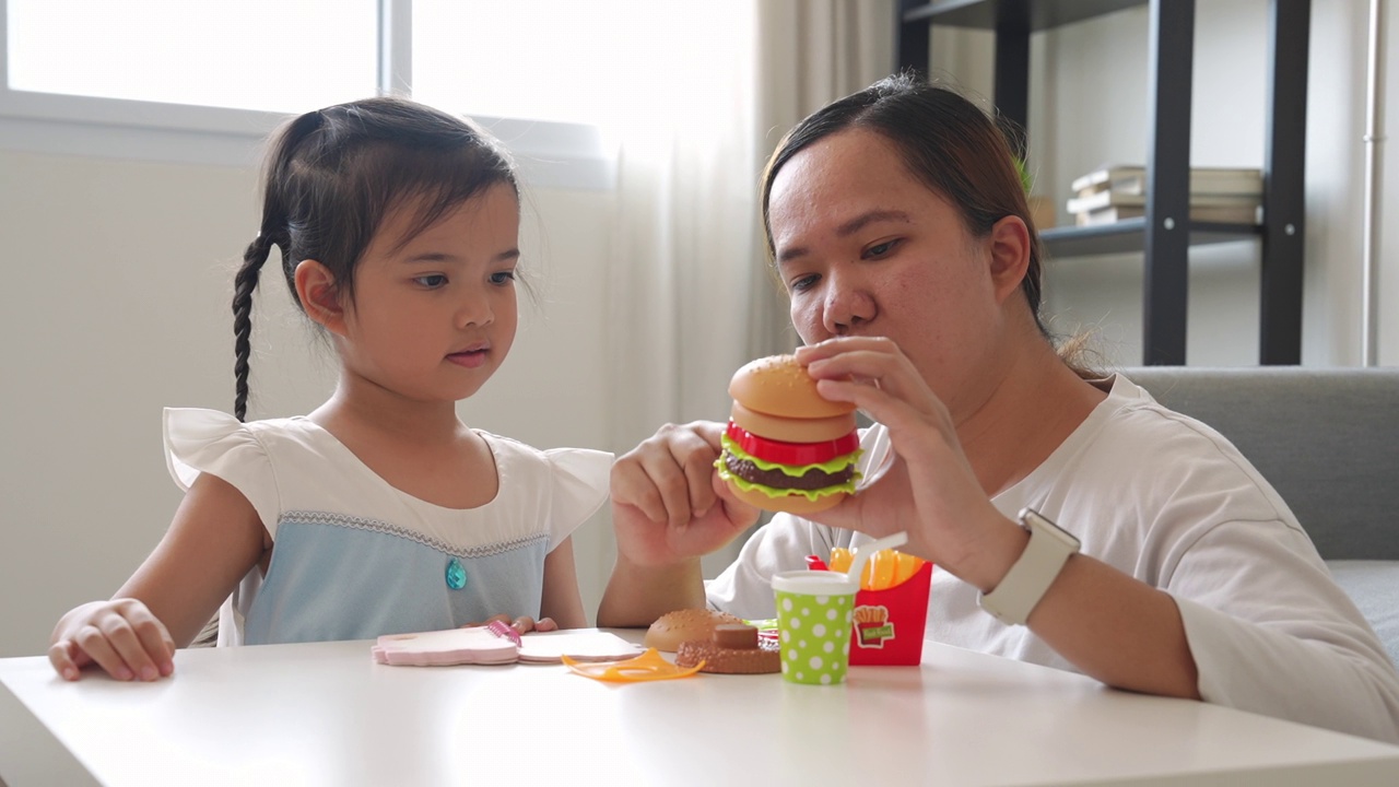 在想象中，妈妈和小女孩一起玩塑料儿童玩具视频素材