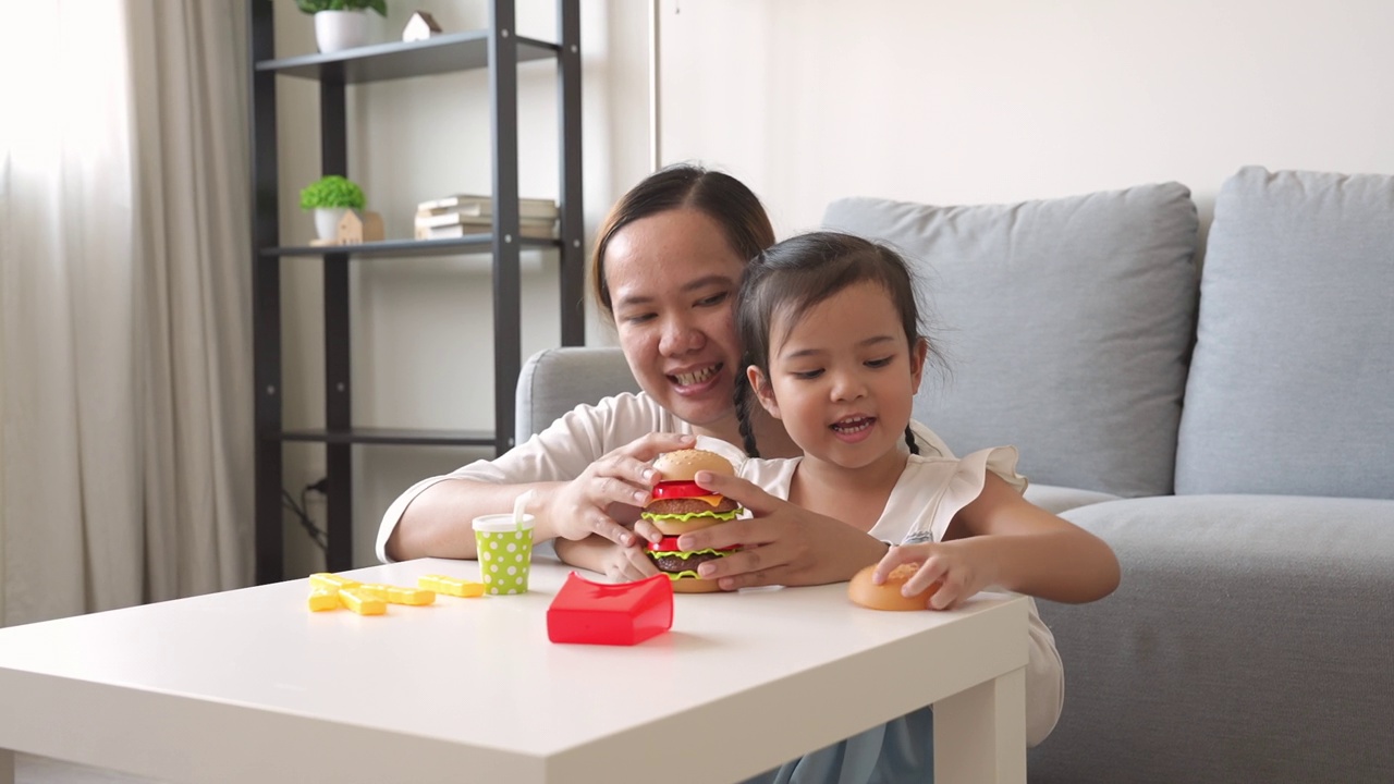 童年的快乐，妈妈和小女孩一起玩塑料儿童玩具视频素材