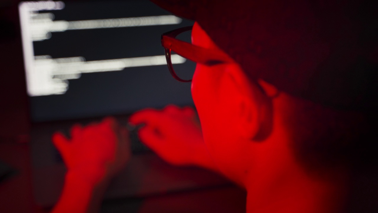 在暗室里靠近黑客的背影，试着用红色应急灯编程入侵电脑。视频下载