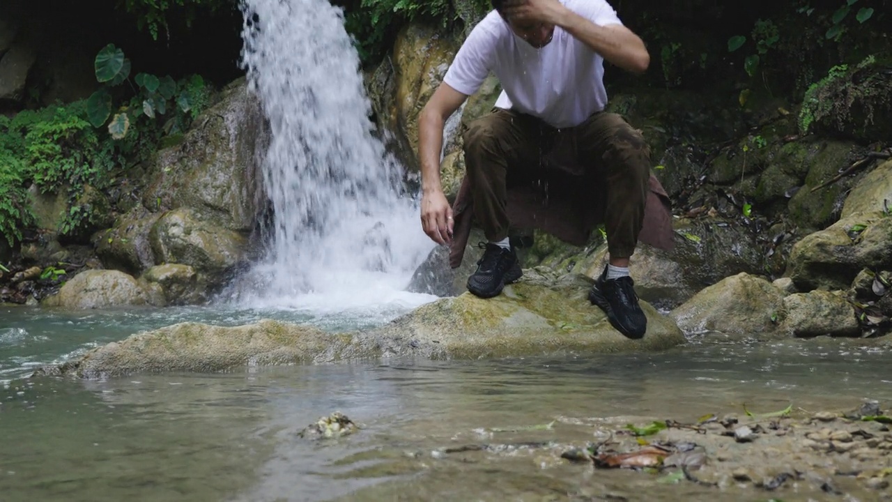 男探险家周末在森林里用河水洗脸视频素材