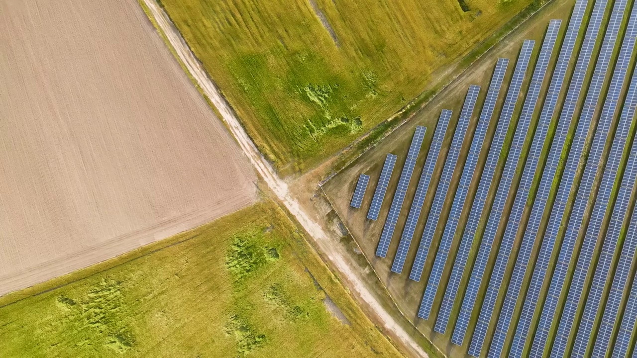 农田旁边的太阳能发电站。绿色田野和太阳能电池板的画面视频素材