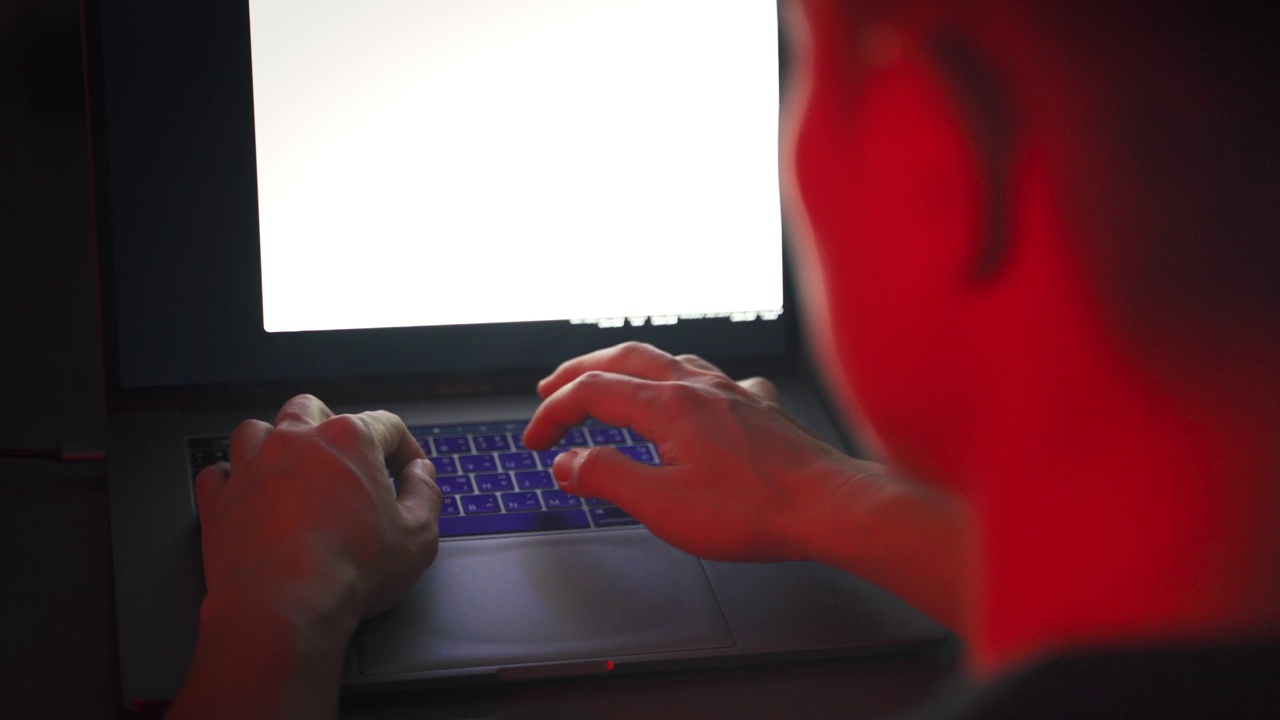 程序员或黑客试图用红色应急灯在电脑中编写代码的电影镜头。视频下载