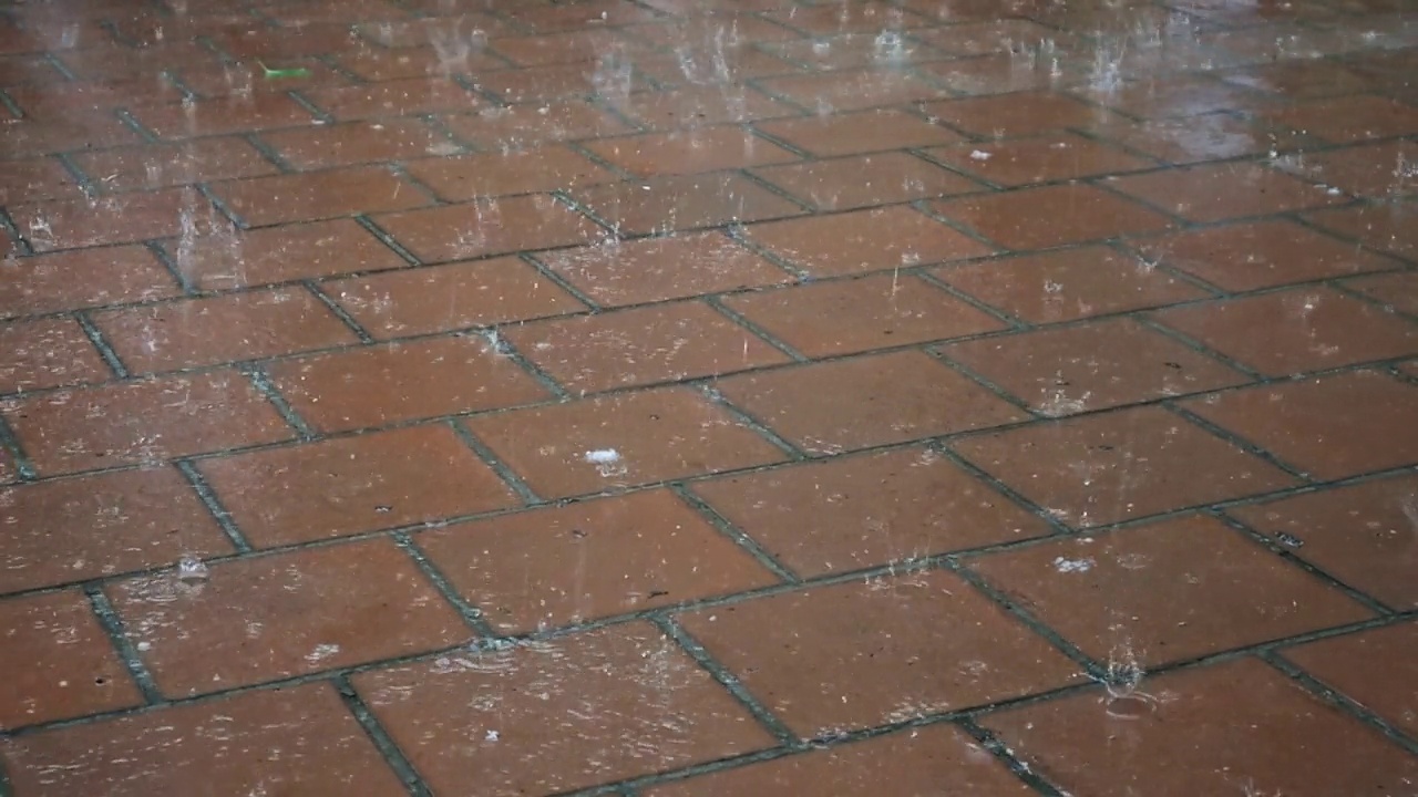 夹杂着冰雹的大雨点落在石板上。视频素材