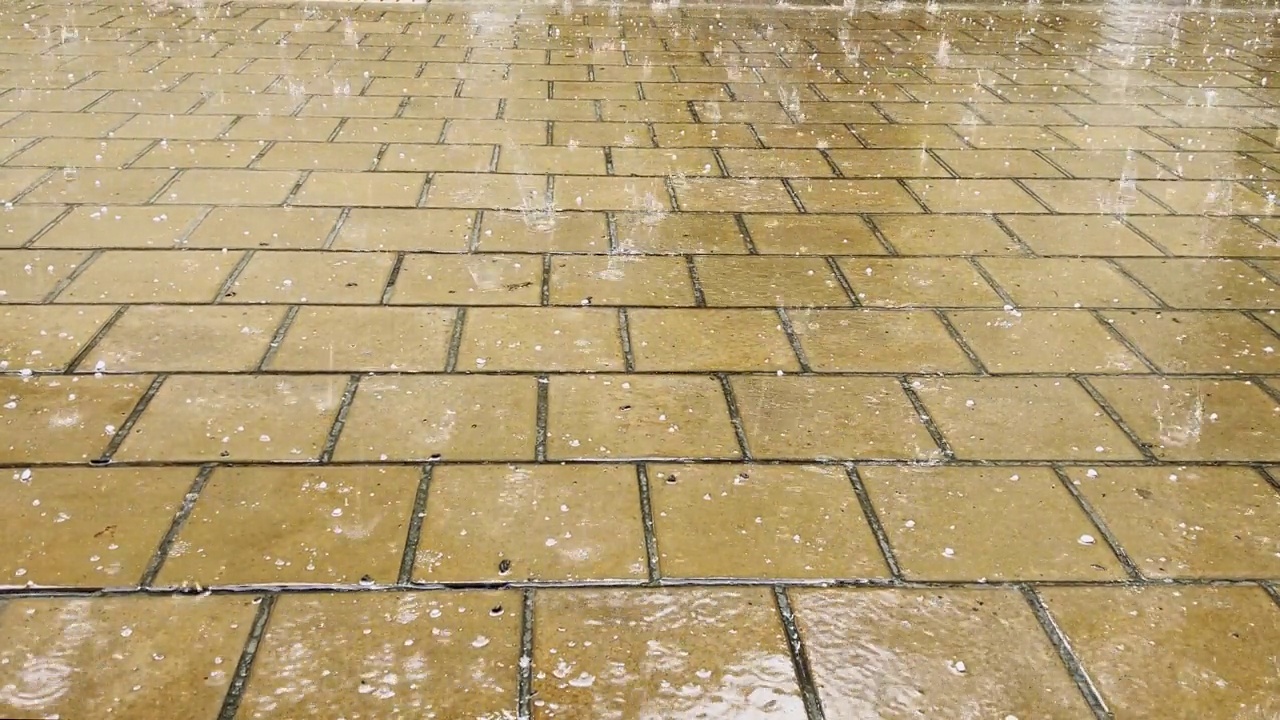 夹杂着冰雹的大雨点落在石板上。视频素材