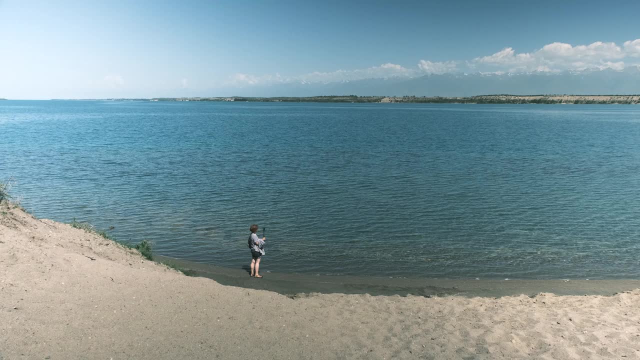 女游客打算在大湖里游泳，并制作一个视频视频素材