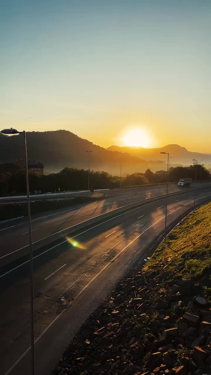 日出时在高速公路上行驶的卡车和汽车视频素材