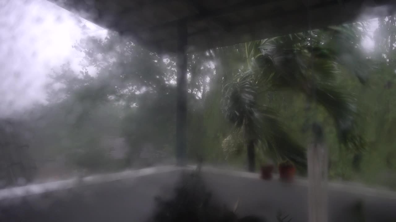 暴雨场景:透过潮湿的窗户拍摄。大雨倾盆，随处可见。可见强风。视频下载