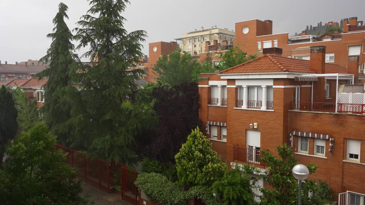 雨下得很大，雨水落在建筑物和树木上。视频素材