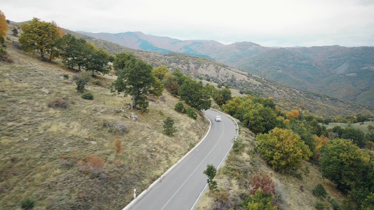 在弯曲的山路上爬坡比赛的跑车鸟瞰图视频素材