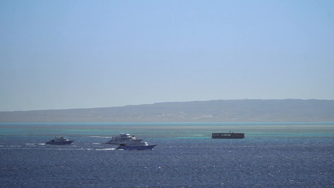 一群游客在埃及赫尔格达的红海吉敦岛附近浮潜和水肺潜水的手持照片视频素材