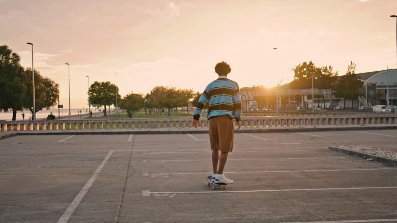 年轻男子平衡滑板在晚上的后景。活跃的家伙骑着长板视频素材