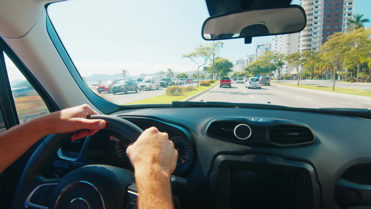 男人在城市里开车。穿着休闲服的业余男司机在城市里驾驶汽车，在左车道上快速行驶视频素材