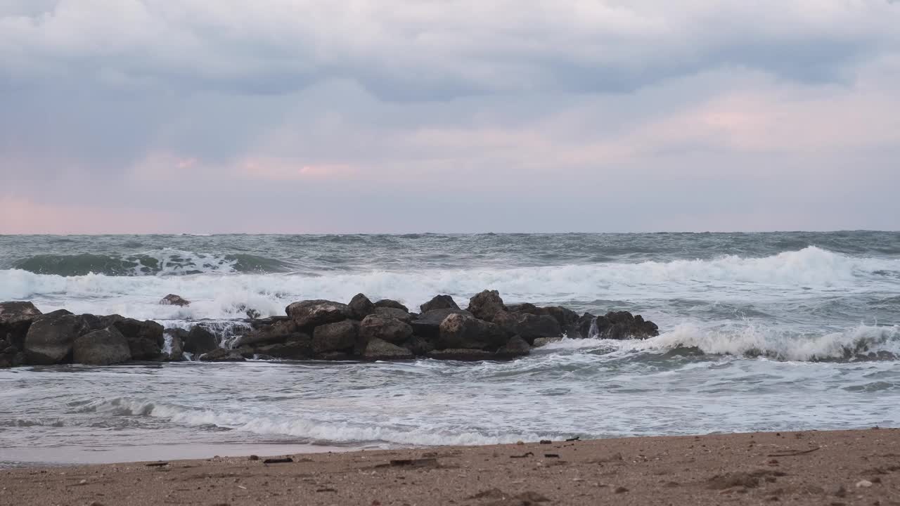 黄昏时分，以色列海滩上暴风骤雨的地中海。海浪冲击着海岸的岩石视频下载