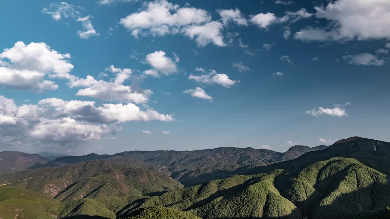 多云的天空移动在绿色的山丘范围为背景的延时场景视频素材