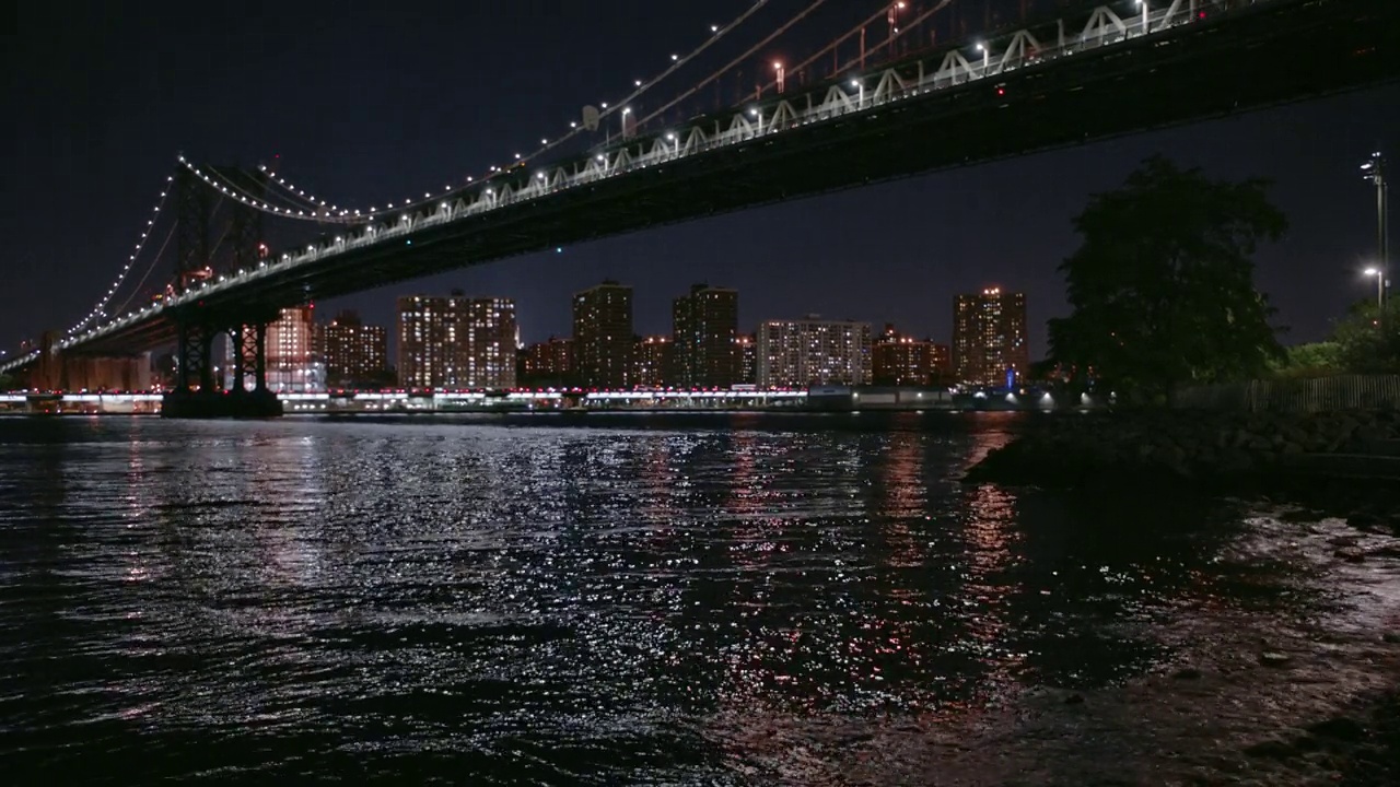 布鲁克林大桥夜景与自由塔横跨河流视频素材