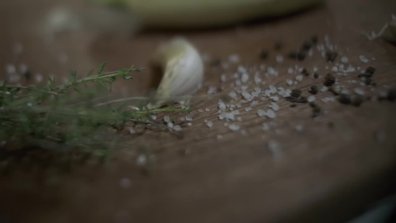 特写的木制砧板与大蒜，香草和西红柿视频素材