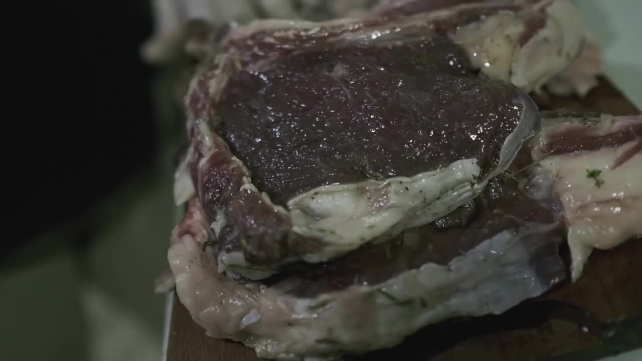 厨师厨房里切肉板上用来做牛排的生肉片视频素材