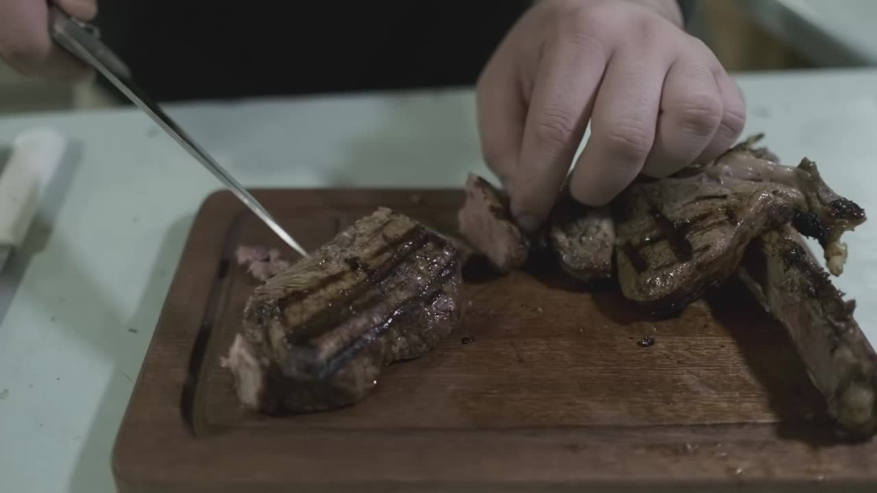 厨师用刀在菜板上切熟肉块视频素材