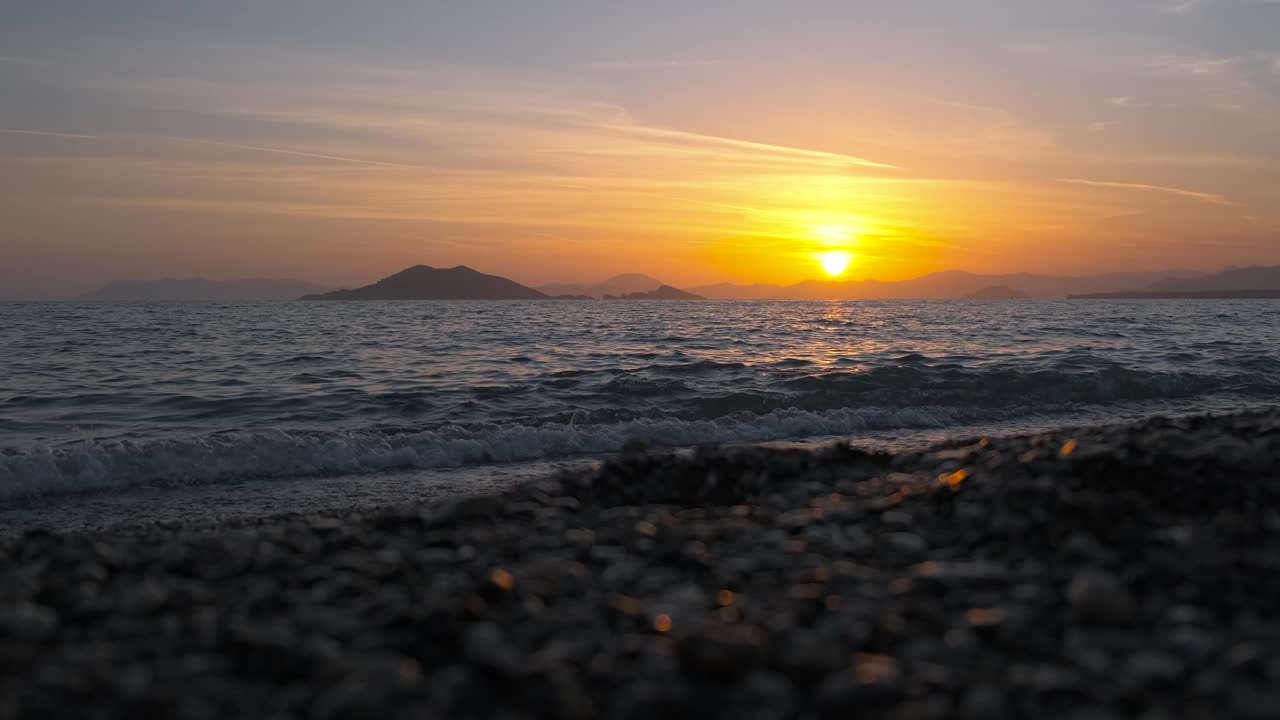 金色的太阳剪影在空旷的海岸线上。视频素材