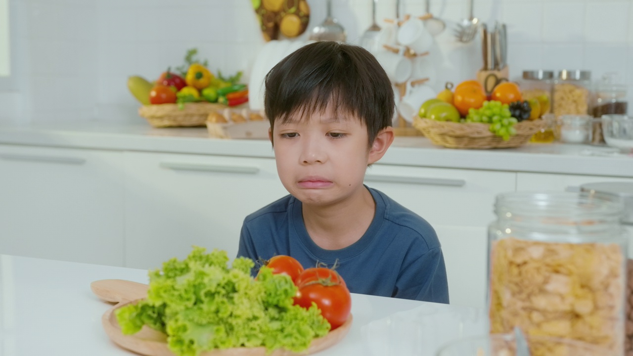 亚洲男孩觉得无聊，不开心就吃蔬菜，养生理念视频素材