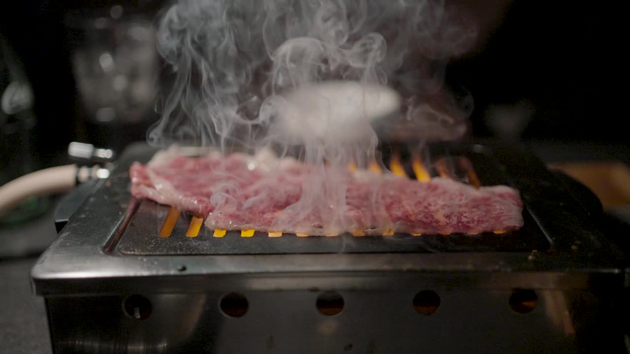 在日式烧饼店烤架上烤新鲜多汁的牛肉片。日式烤牛肉。视频素材