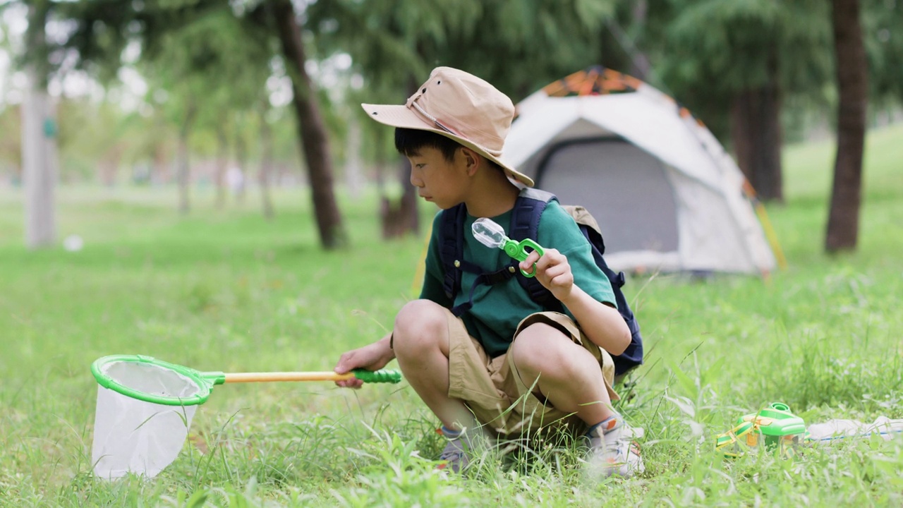 亚洲小学生在户外捉昆虫视频素材