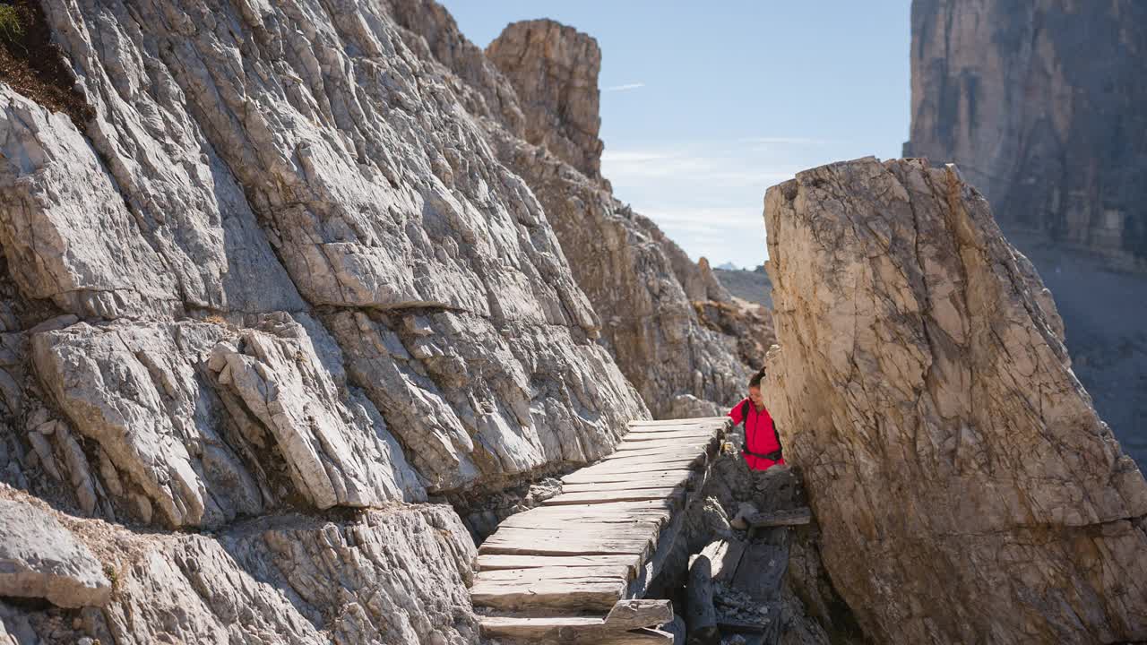 年轻的女性徒步旅行，周围是雄伟的山景视频素材