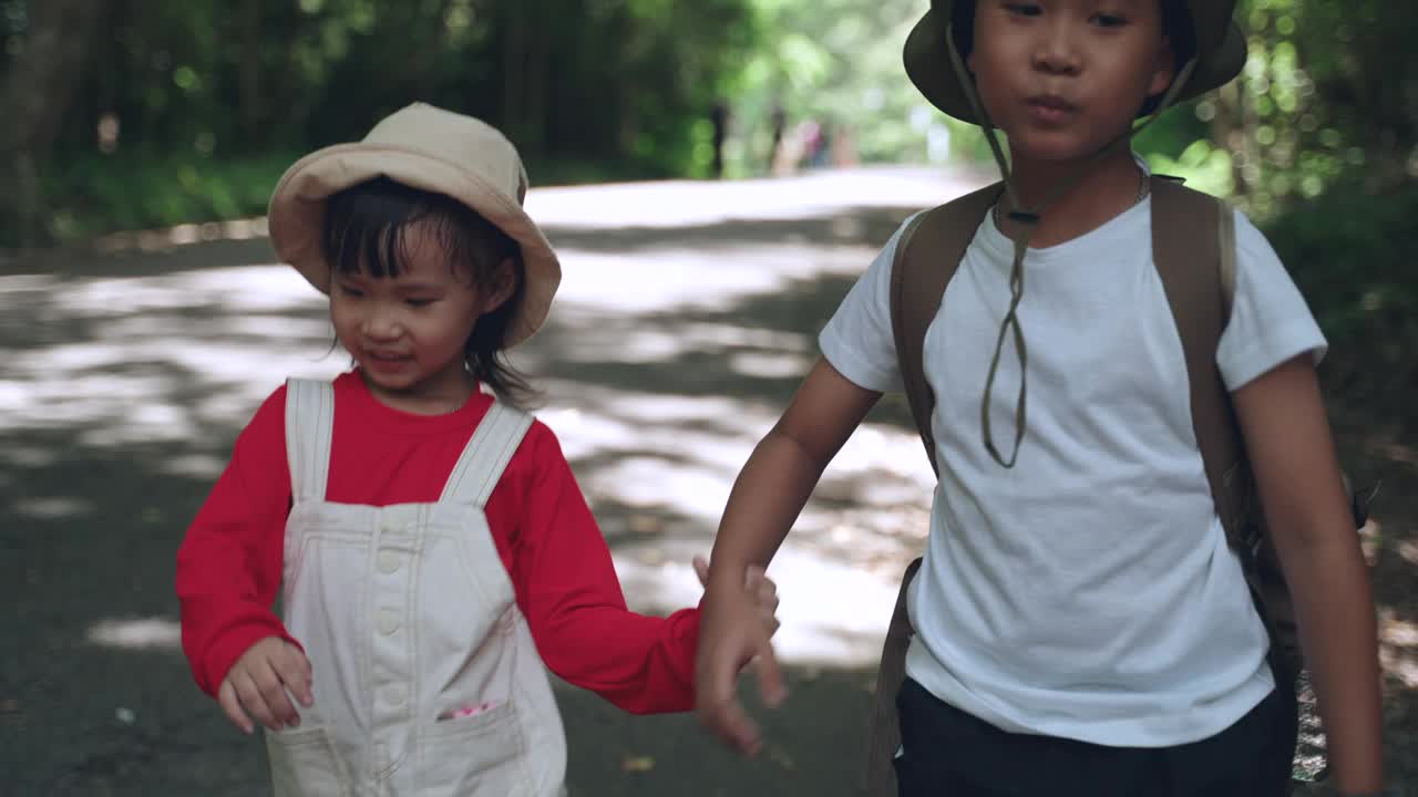 亚细亚兄妹正在森林里散步旅行大自然。视频下载