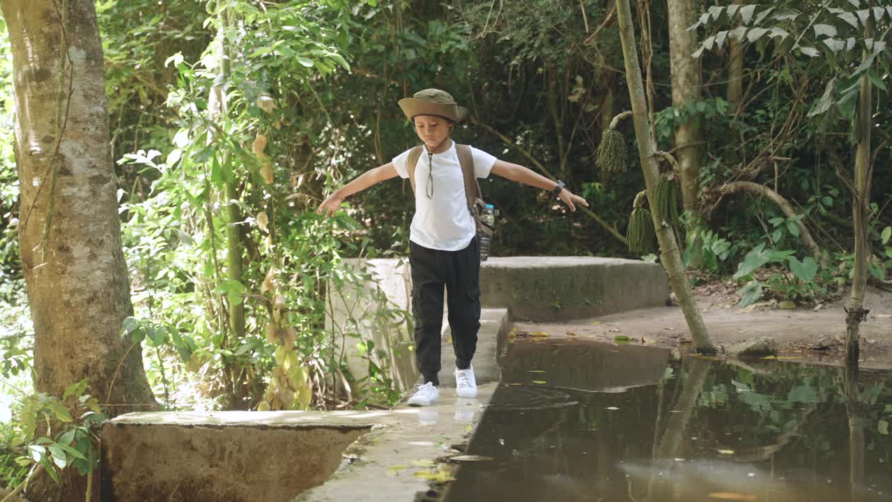 快乐的男孩在森林里徒步旅行。视频素材