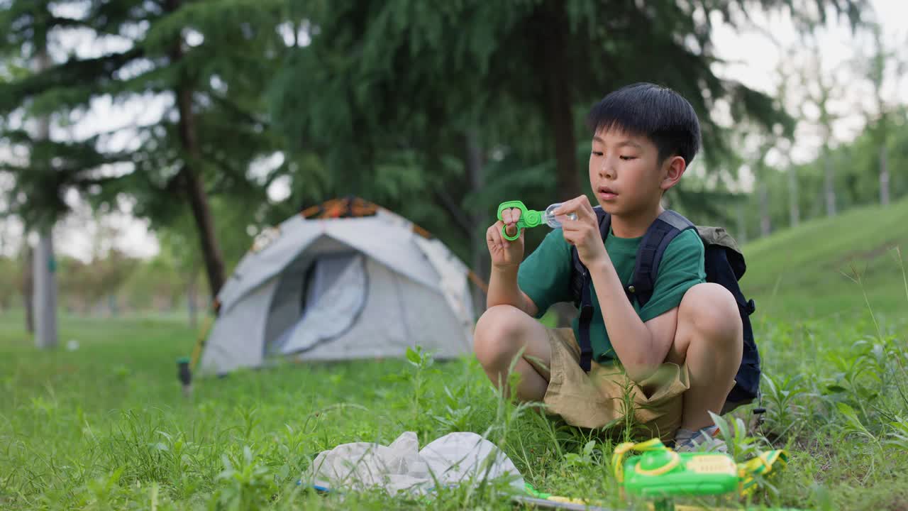 亚洲男孩在露营时抓昆虫视频素材