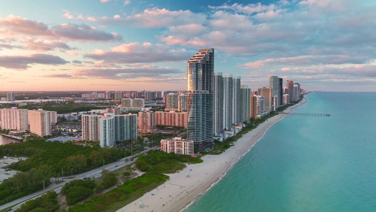 阳光岛海滩城市在日落时的高角度视图，在大西洋海岸的海滨有昂贵的高层酒店和公寓建筑。佛罗里达州南部沿海的美国旅游基础设施视频素材