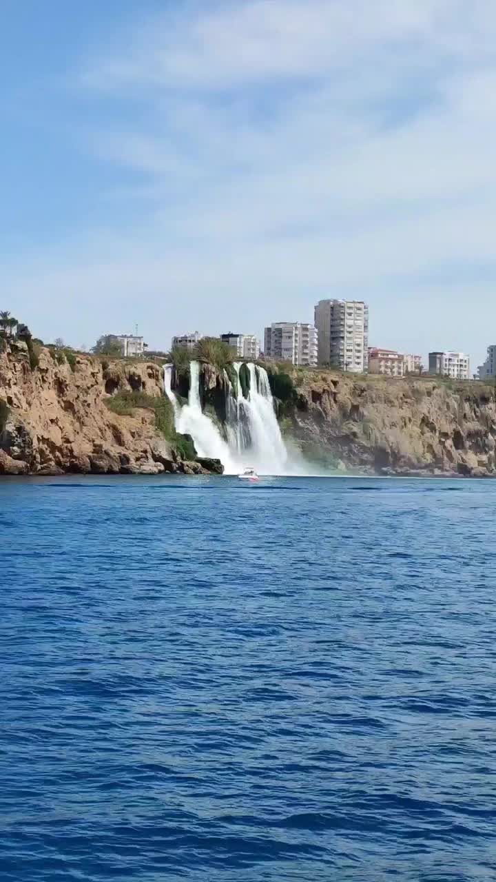 在棕色山脉和蓝色地中海的背景下，一个美丽的大瀑布视频素材