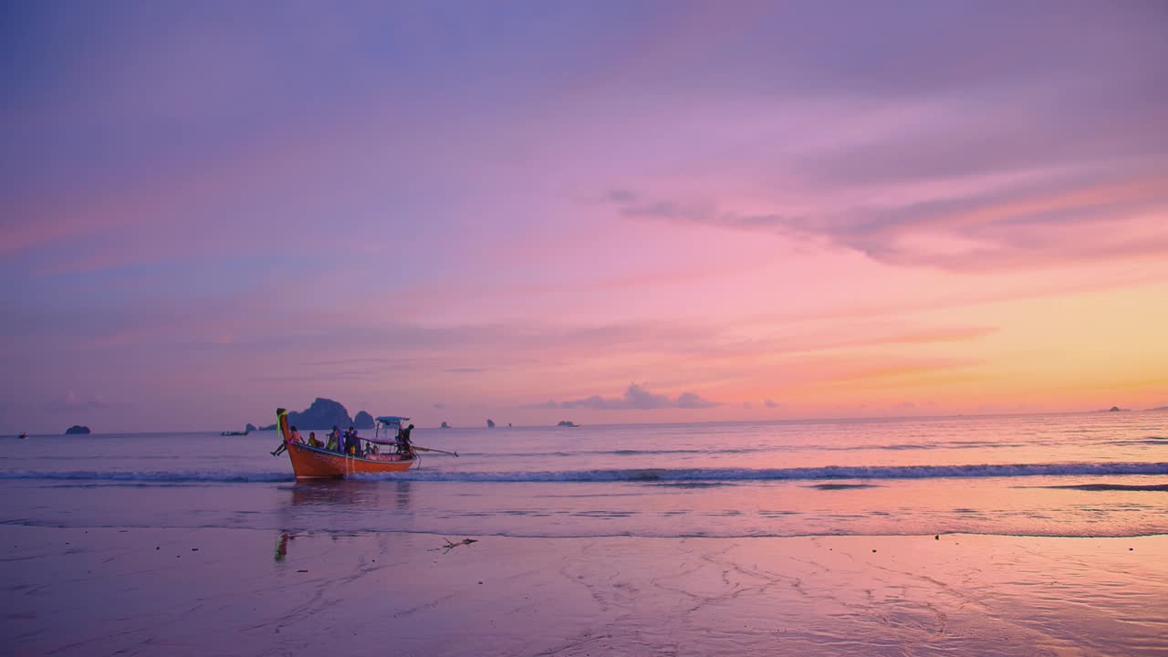 美丽的令人惊叹的日落在热带海洋安达曼海海滩与彩色天空和长尾船在奥南，甲米，泰国的夏天，旅游度假度假旅行的目的地概念视频素材