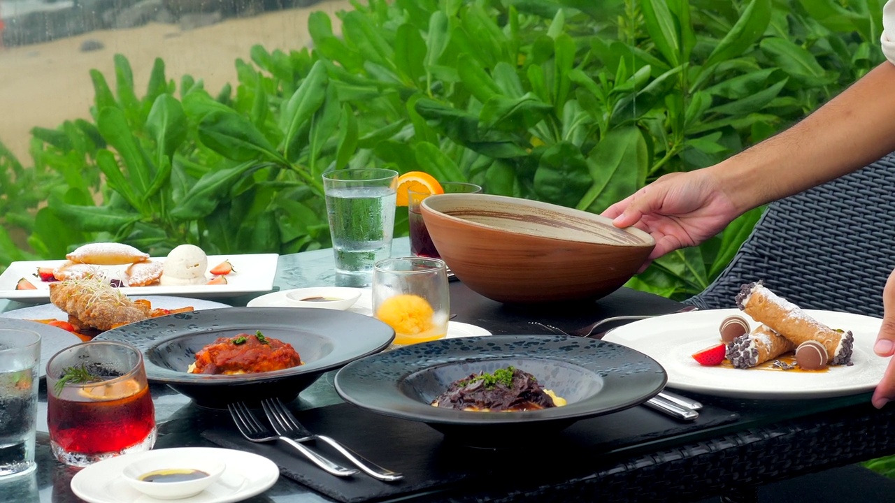 在海边的一家餐馆里，侍者侍候餐桌视频素材