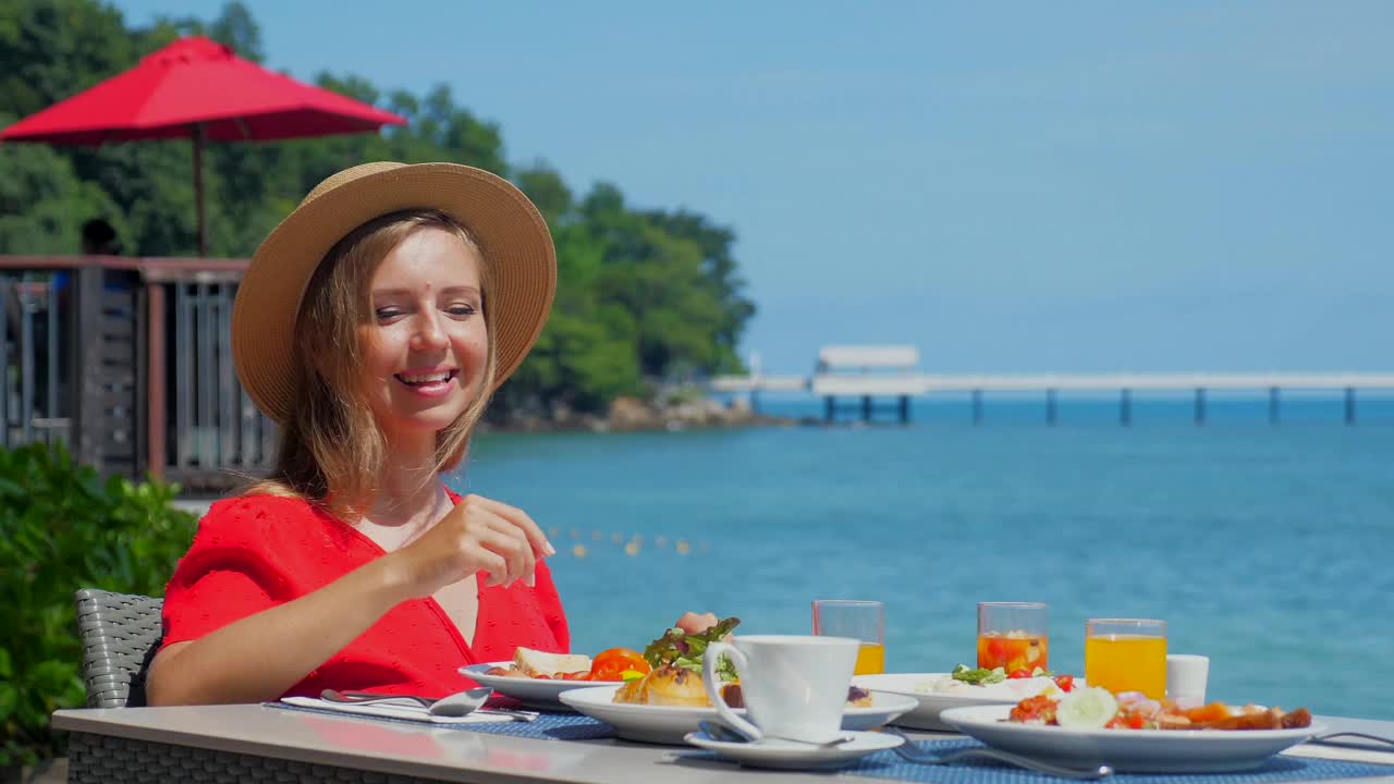 旅行女人在自助早餐上享受美丽的海景视频素材