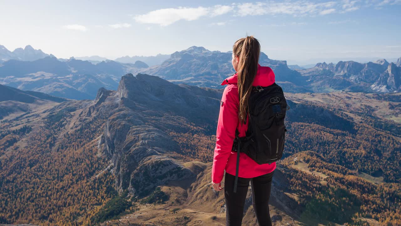 女人从山顶俯瞰雄伟的山谷，享受着令人叹为观止的景色视频素材