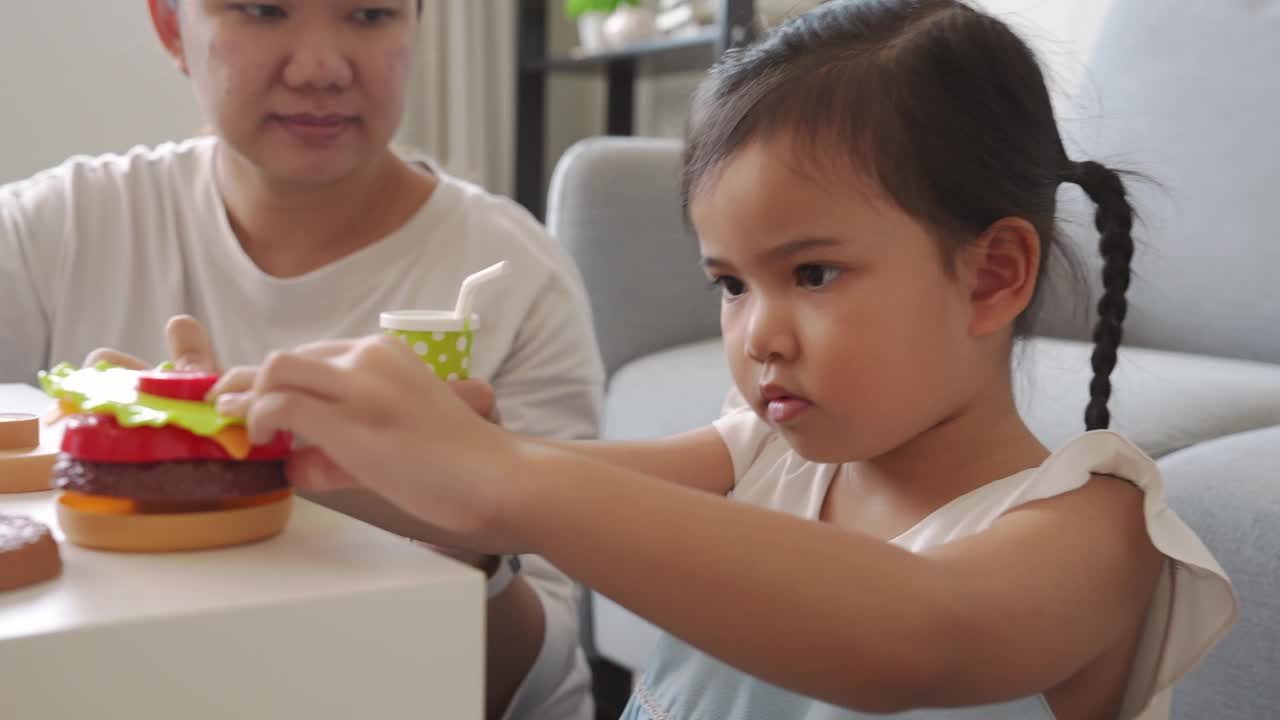 童年的快乐，妈妈和小女孩一起玩塑料儿童玩具视频素材