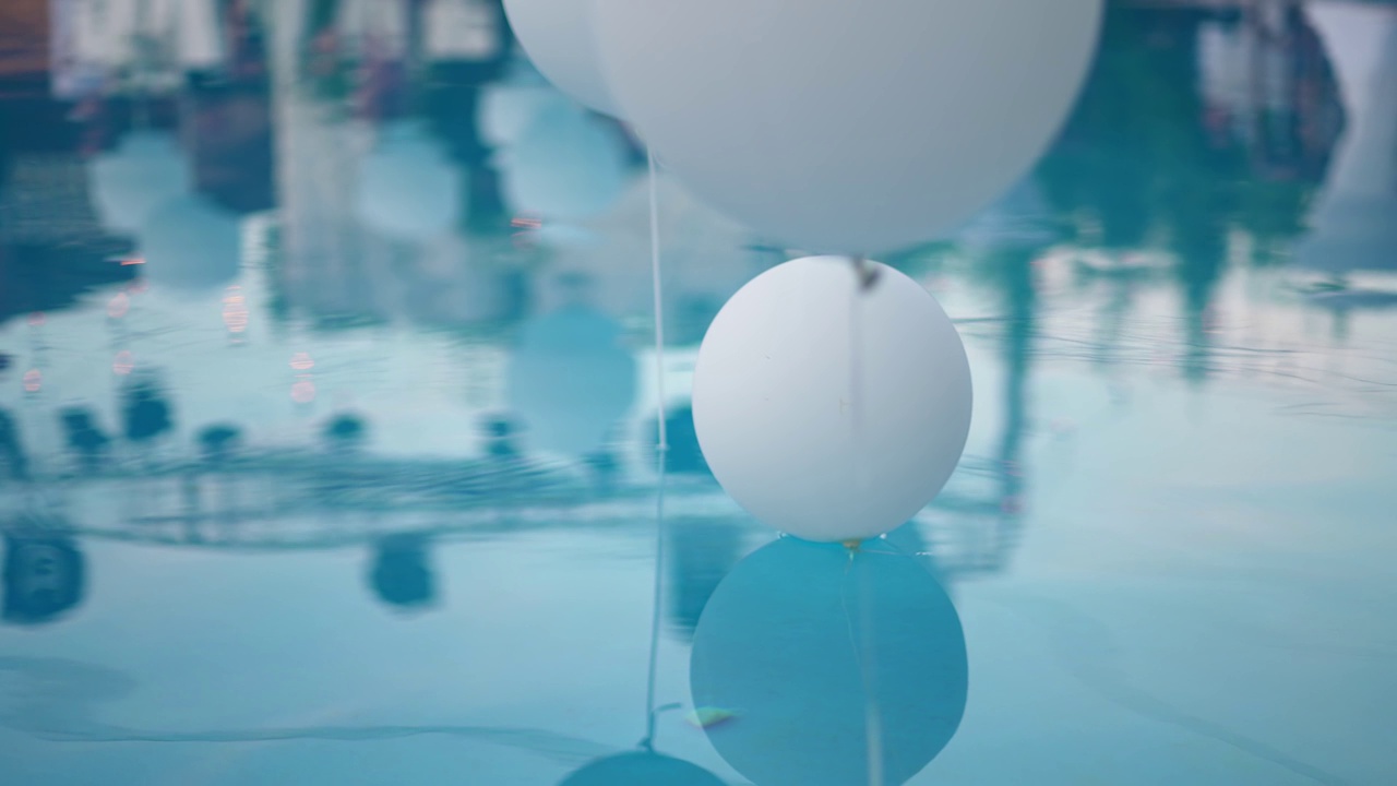 池畔婚礼派对上的氦气装饰气球在水上视频素材
