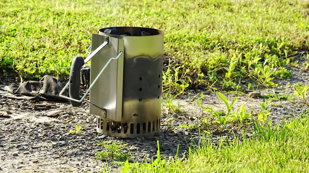 在空地上点燃煤的起动器。视频素材