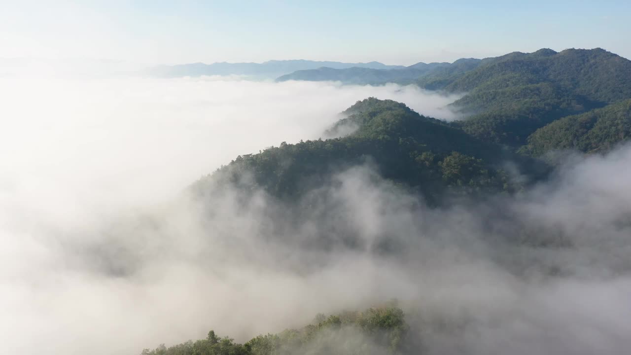 无人机拍摄的低悬云漂浮在山上的树木。视频素材