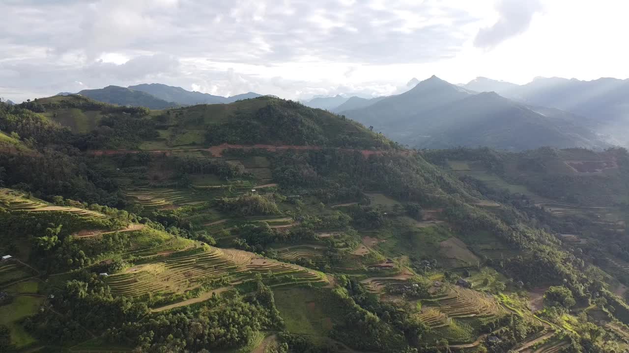 从夕阳下充满阳光和稻田的山景中飞离视频素材