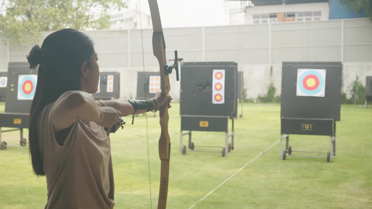 迷人的亚洲女性在靶场练习射箭。射箭。视频素材