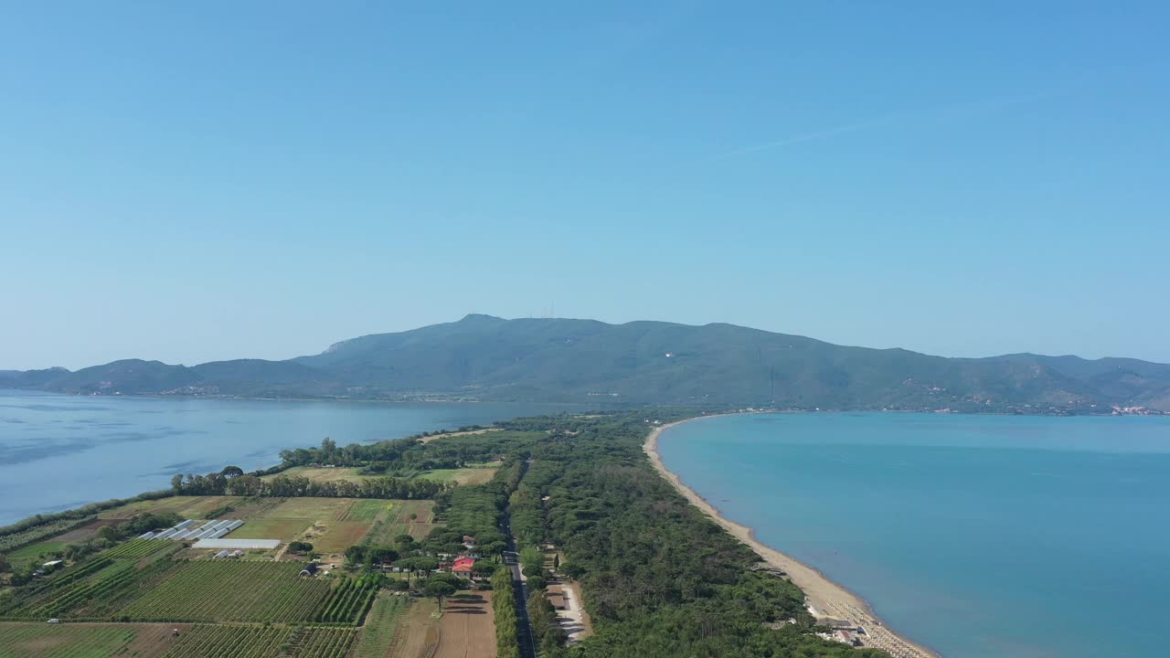 在一个阳光明媚的夏日，蓝天碧水，格罗塞托省托斯卡纳的阿根廷山旁边，奥尔贝特洛泻湖和蒂勒尼安海之间的Giannella海滩的美丽无人机视图。视频素材