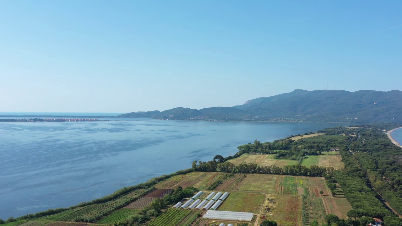 在一个阳光明媚的夏日，蓝天碧水，格罗塞托省托斯卡纳的阿根廷山旁边，奥尔贝特洛泻湖和蒂勒尼安海之间的Giannella海滩的美丽无人机视图。视频下载