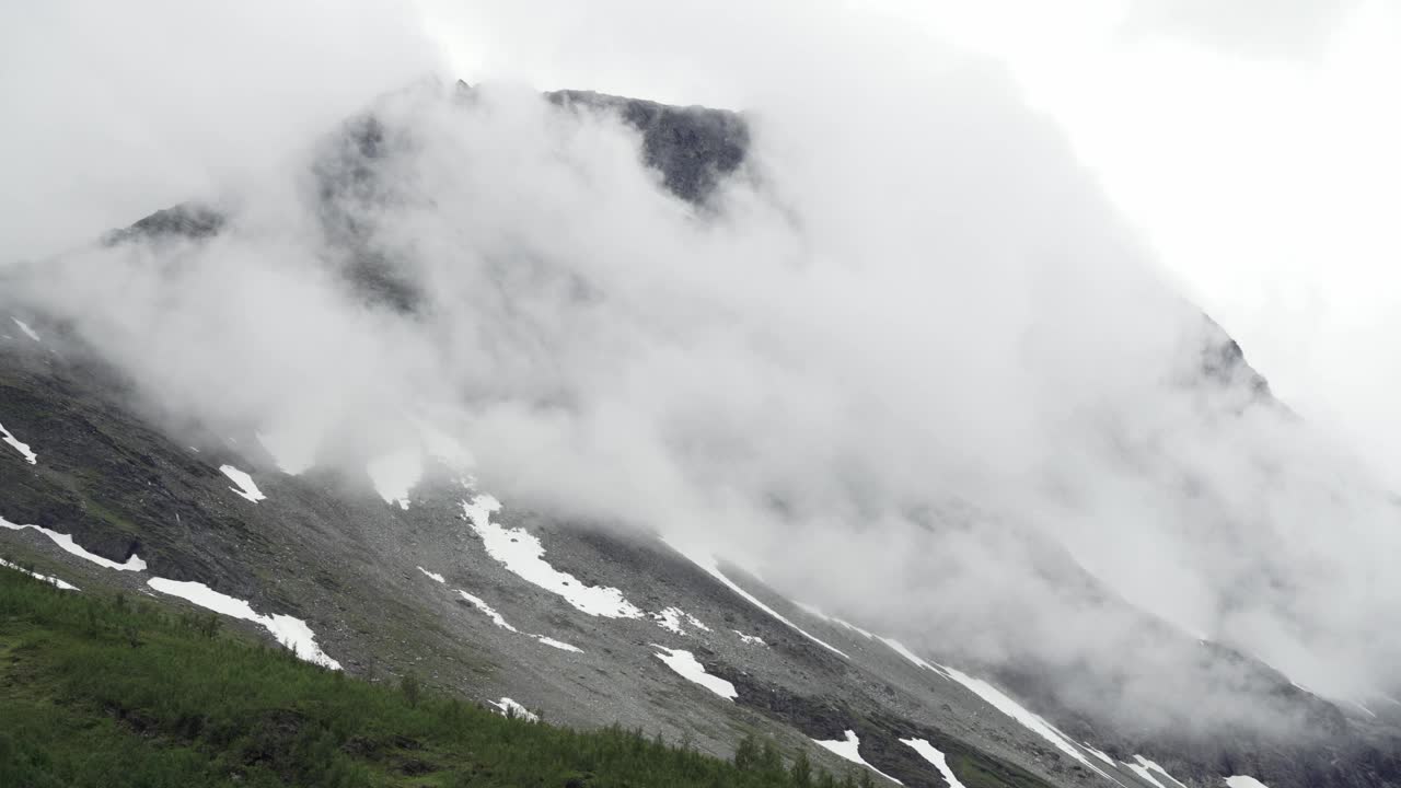 挪威的一座大山部分被云层覆盖，前景是森林视频素材