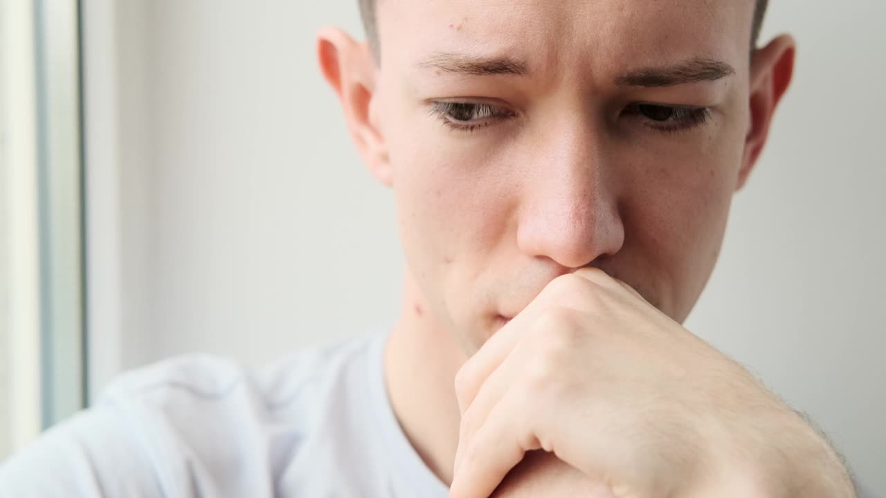 一个白人男子在窗前沉思视频素材