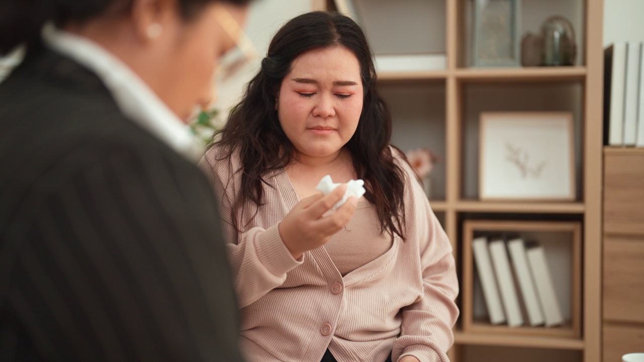 亚洲年轻肥胖女性在心理治疗中与成熟成年女性会面的特写。视频素材