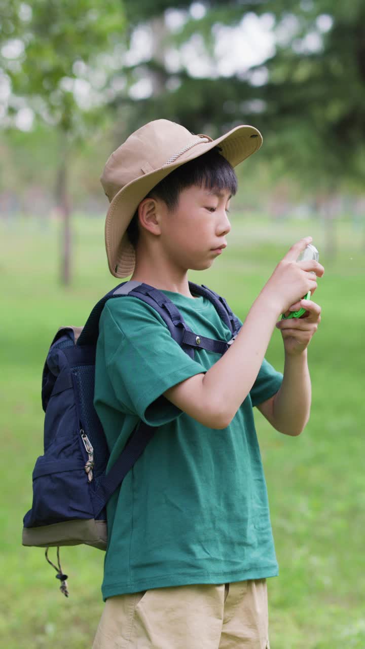 一个亚洲男孩正在观察他捉到的昆虫视频素材